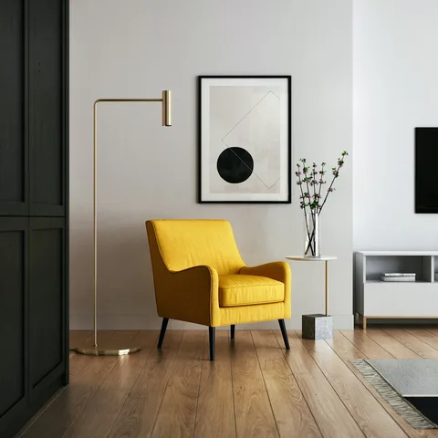 Ochre reading chair beside a brass floor lamp