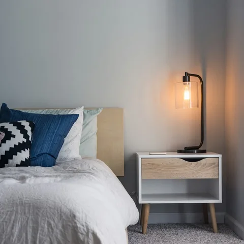 Amber glass bedside lamp glowing on a nightstand