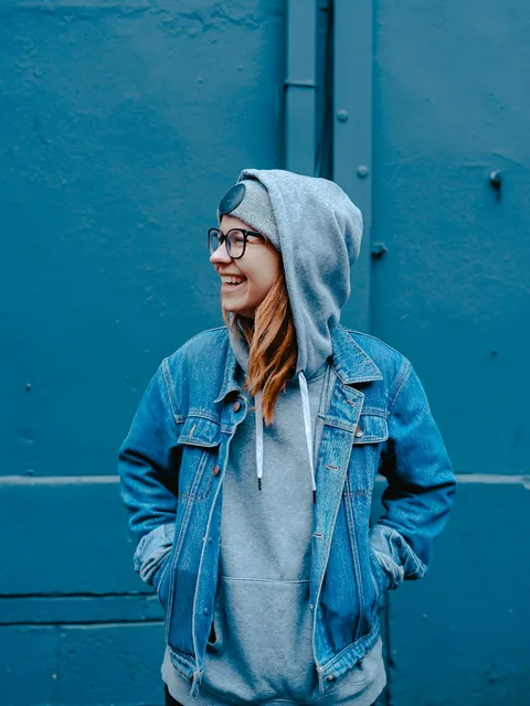 Street-style editorial against a blue wall
