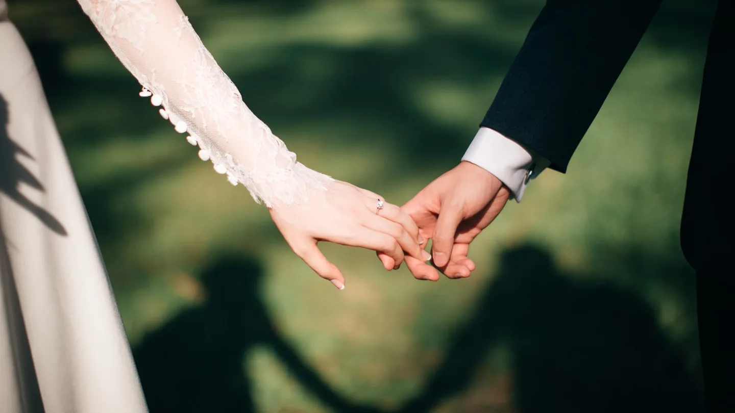 A couple walking hand in hand through golden evening light